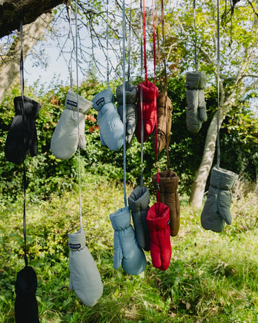 Navy blue vegan winter gloves made from recycled materials hanging outdoors on strings. - The New Orchard - ⁠Navy Blue