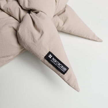 Light beige vegan capuche with pointed ends made from recycled materials, featuring a black label. - The New Orchard - Light Beige