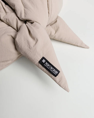 Light beige vegan capuche with pointed ends made from recycled materials, featuring a black label. - The New Orchard - Light Beige