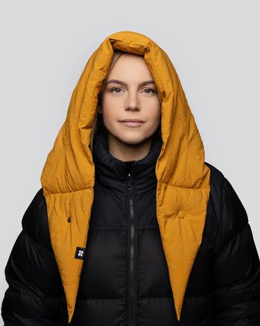 Amber yellow vegan puffer hood made from recycled materials over black jacket. - The New Orchard - Amber Yellow