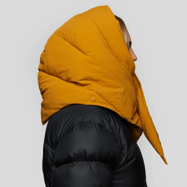 Amber yellow vegan puffer hood with pointed tip, made from recycled materials, worn over black jacket. - The New Orchard - Amber Yellow