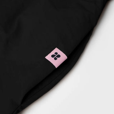 Black vegan skirt made from recycled materials with a small pink brand tag. - The New Orchard - Black / S